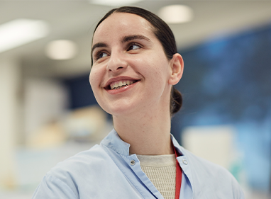 a scientist is smiling and looking up to her right